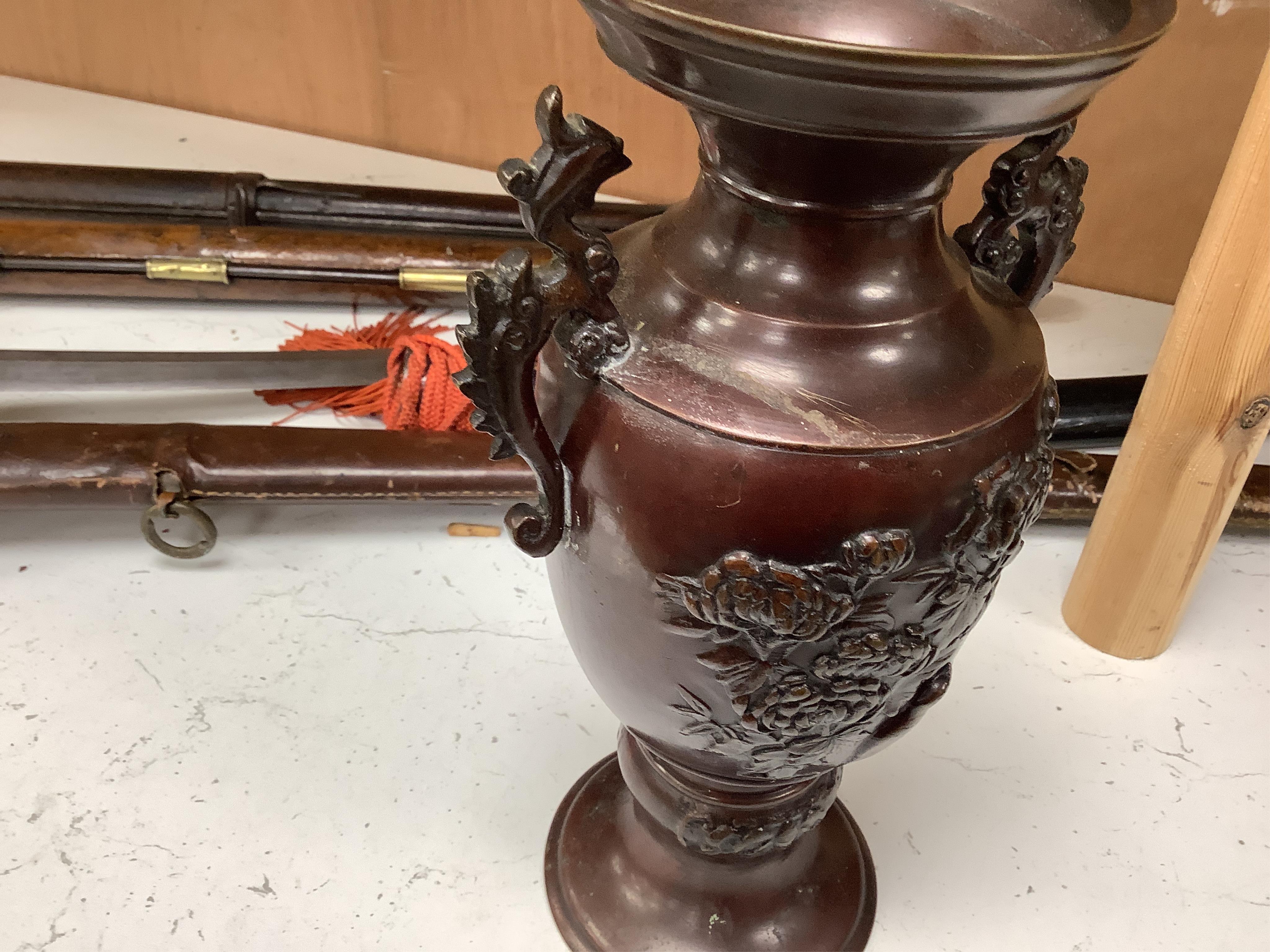 A pair of Japanese two handled bronze vases decorated in relief with birds and flowers, 26cm high. Condition - good